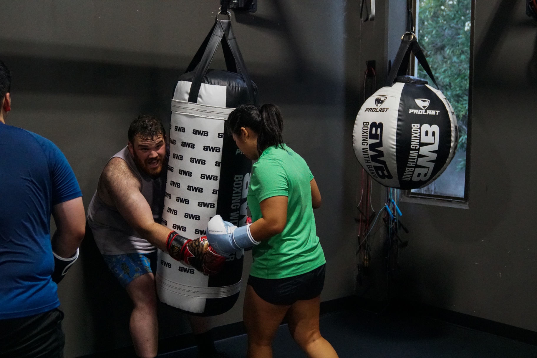 Two students working a partner drill on the heavy bag