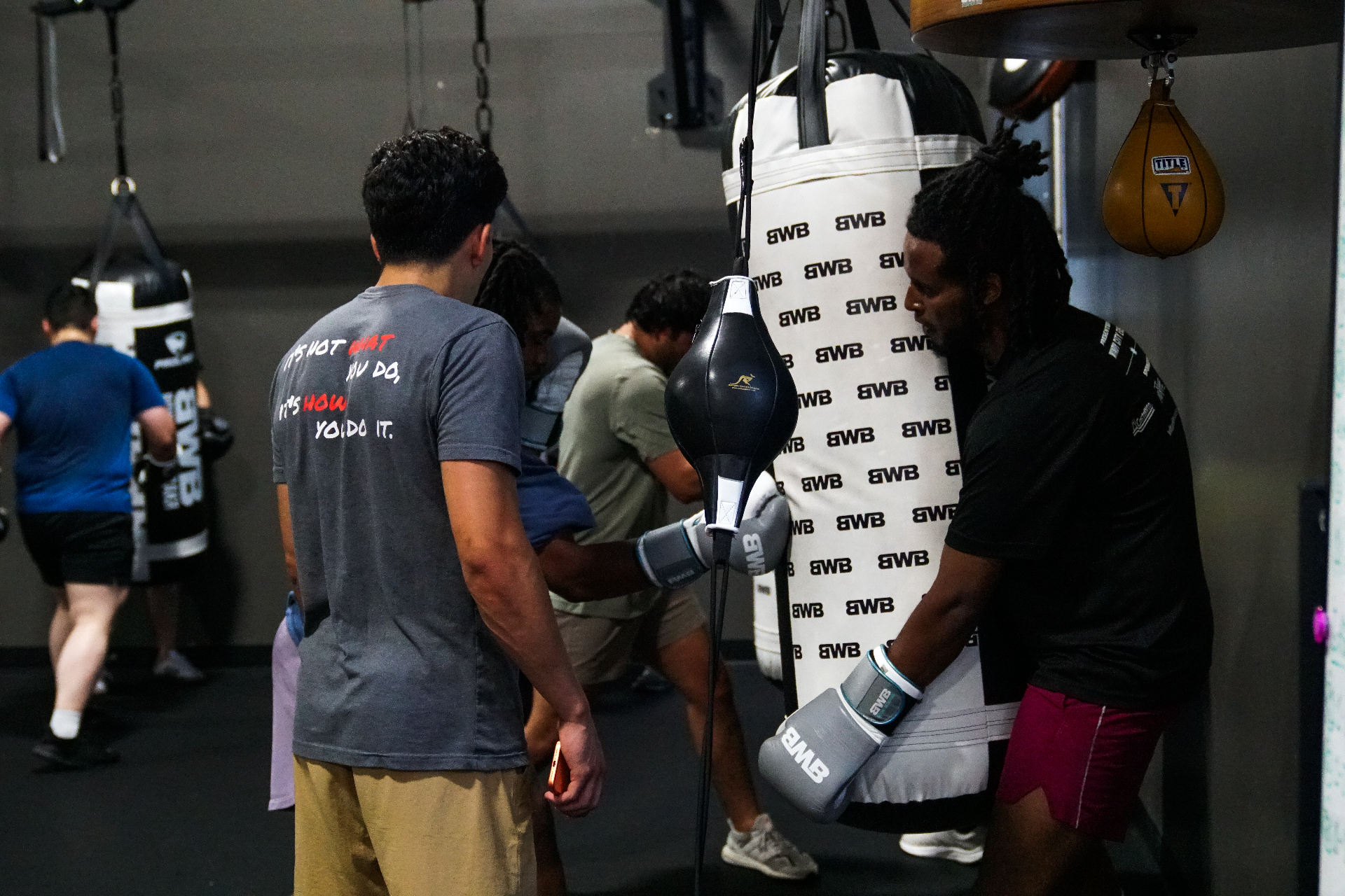 Coach Bakr leading a group heavy-bag session at Boxing With Bakr