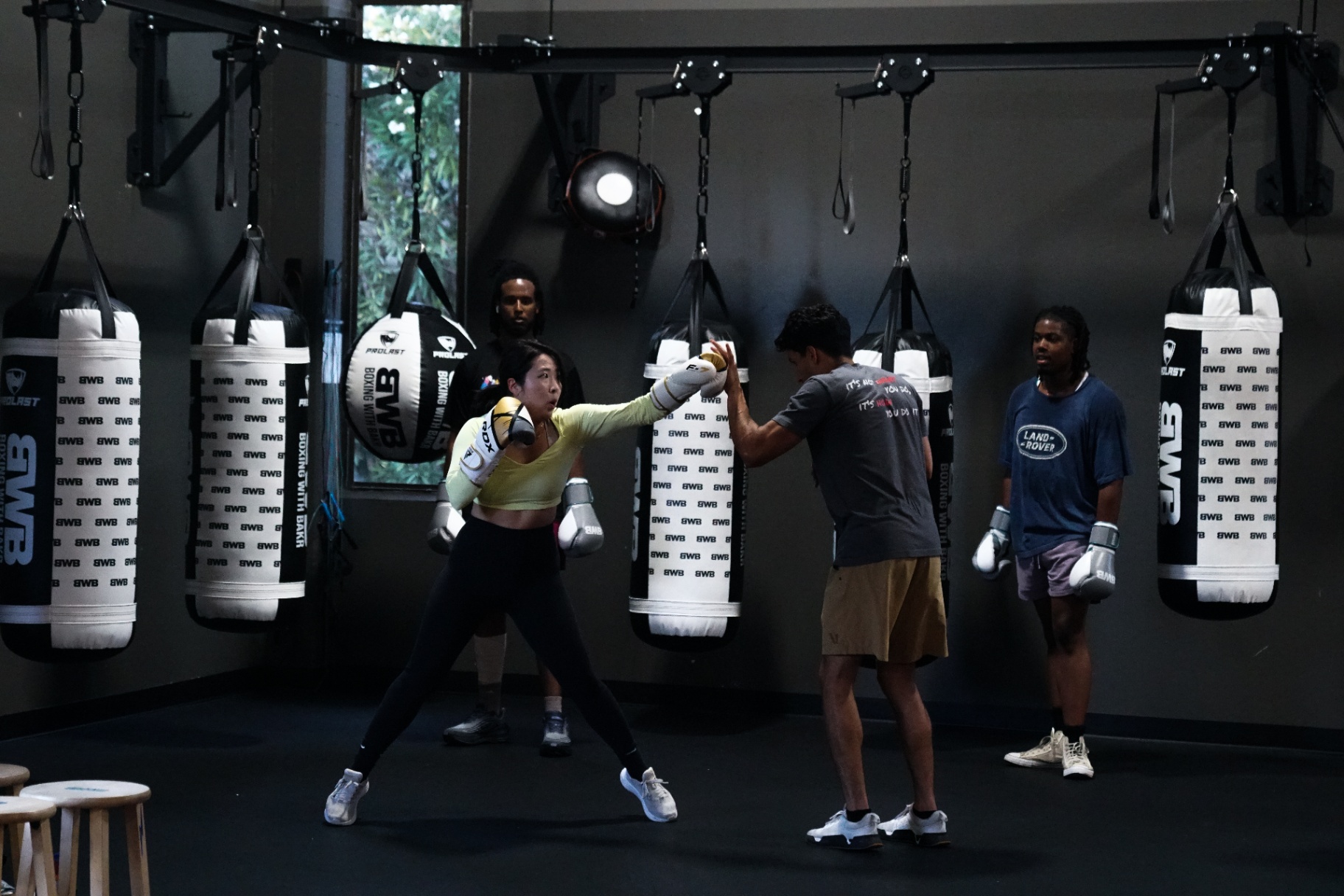 Coach Bakr coaching a fighter on the heavy-bag wall at BWB