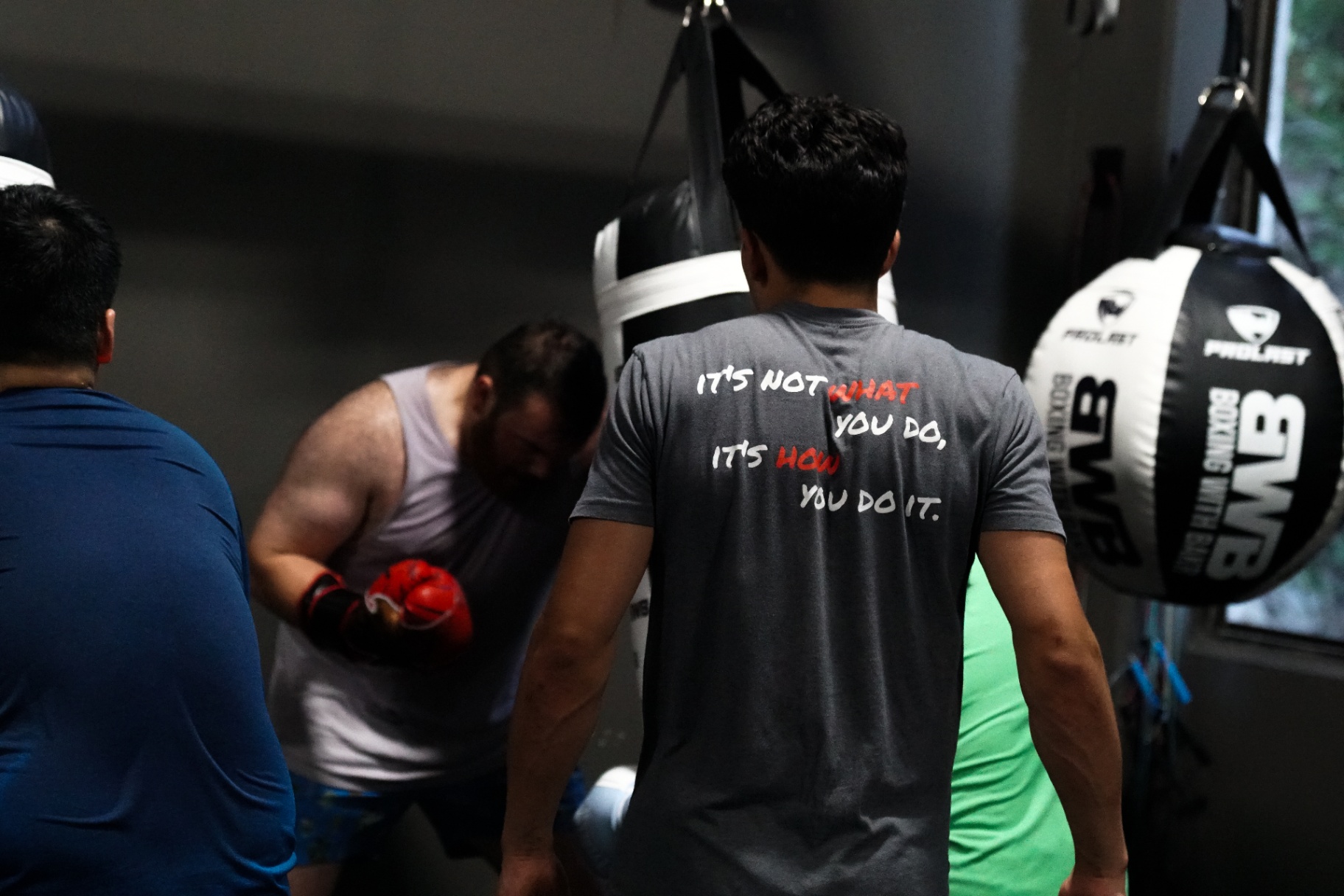 Coach Bakr coaching between the heavy bags