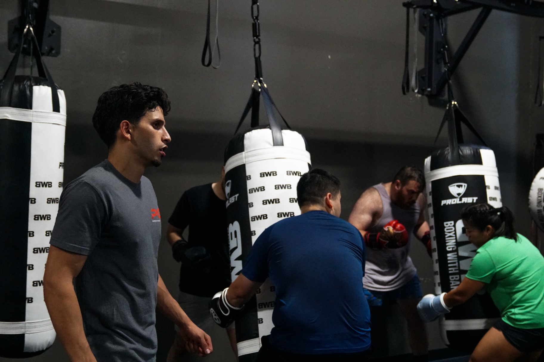 Coach Bakr circling the group during heavy-bag rounds