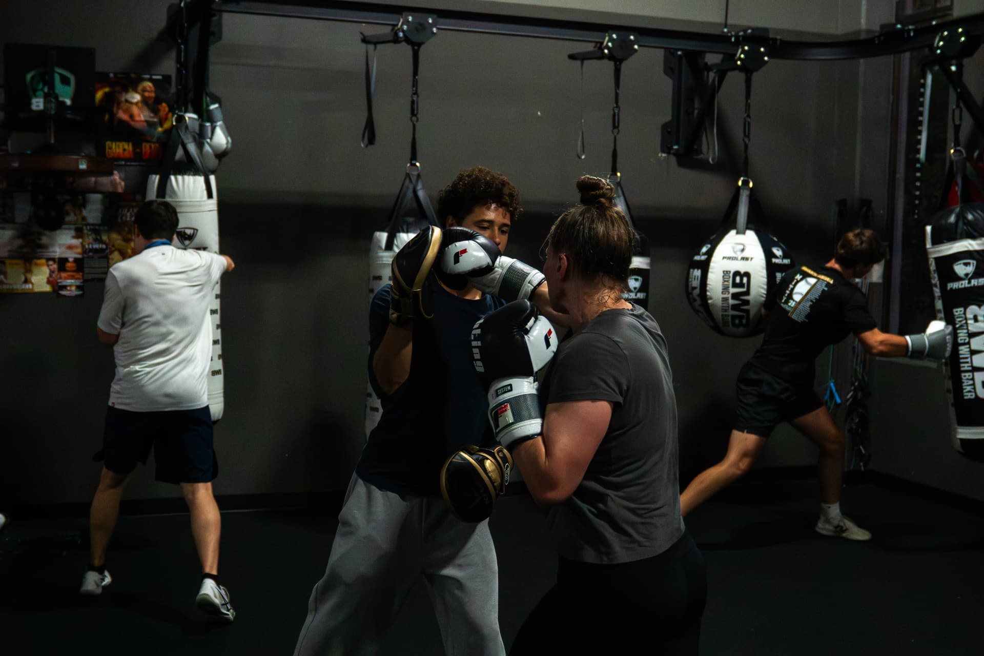 Coach Devin holding pads for a student in the BWB bag room