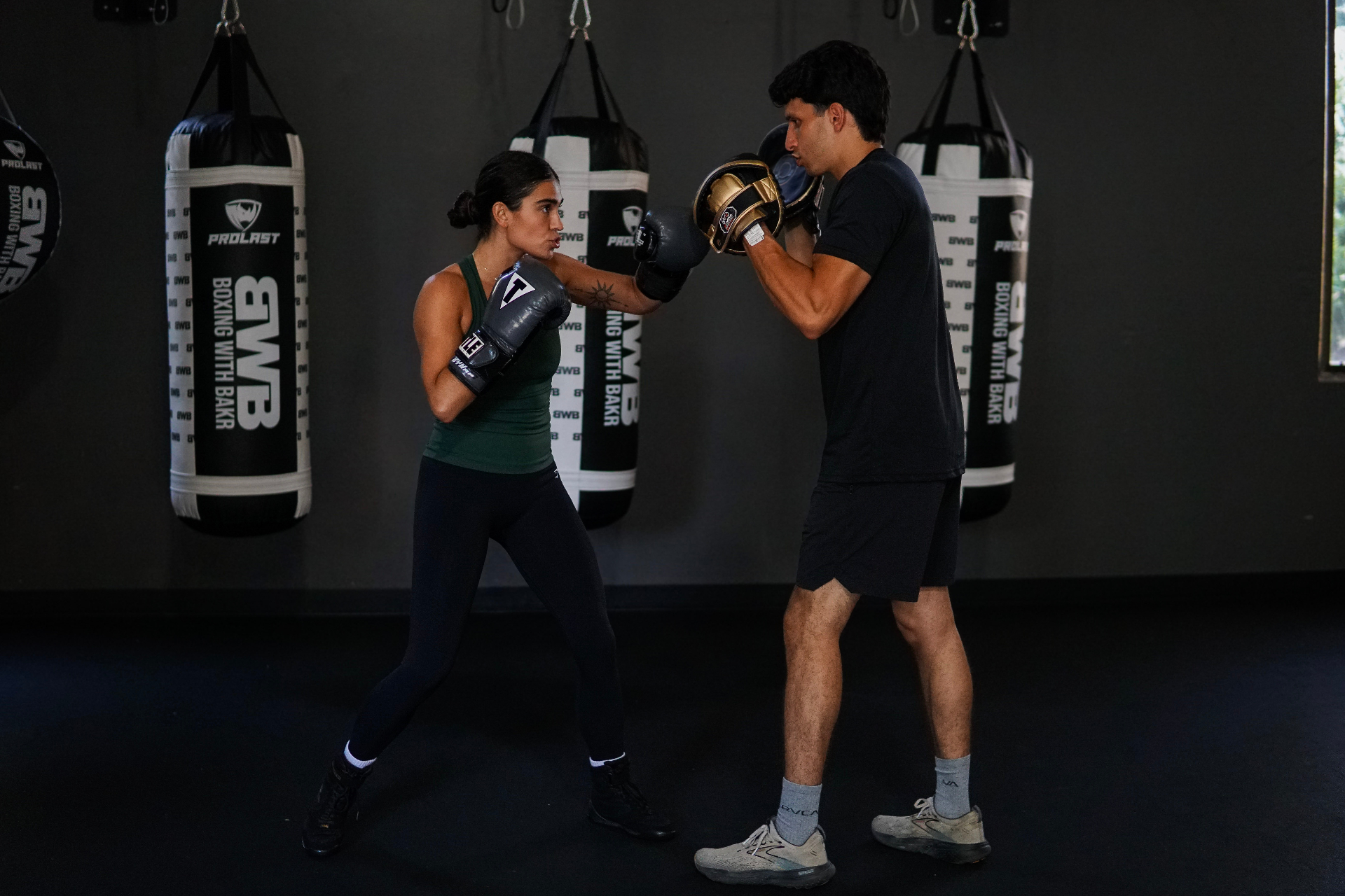 Coach Bella mid-combination on the mitts with Coach Bakr in the bag room