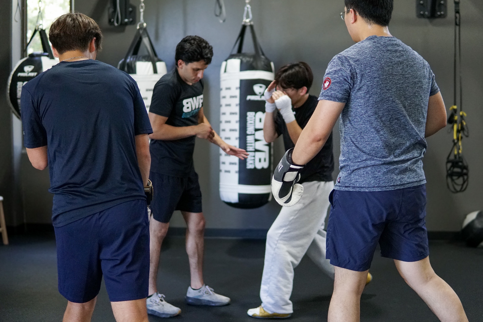 Coach Bakr coaching a small-group footwork drill on the bag floor at BWB