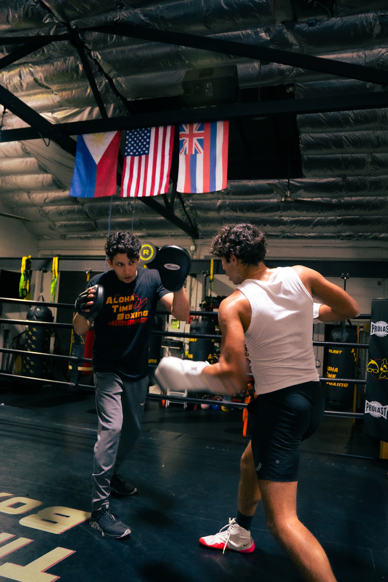 Raj working mitts in the ring with a coach holding pads